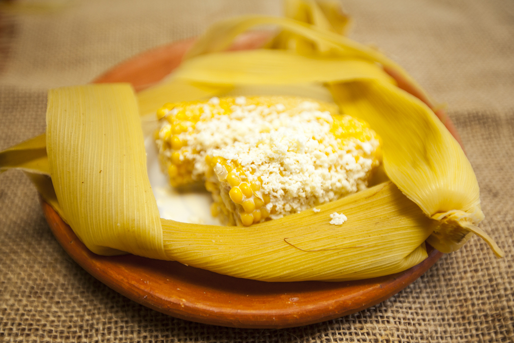 Elotes locos bañados en mantequilla y queso rallado.