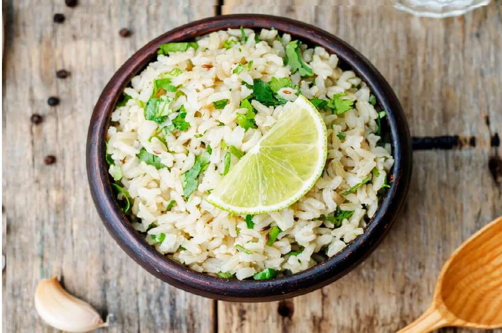 El arroz integral es un tipo de arroz de color marrón, tiene un sabor a nuez, a menudo se cocina con cilantro, limón y ajo. Este se hizo originalmente remojándolo en agua durante varios días, el color marrón resultó del que se oxidó y se volvió marrón cuando se cocinó. Además, comer este platillo es mucho más saludable que comer arroz blanco porque contiene muchas más fibras, vitaminas y algunos antioxidantes. Este platillo también tiene más gramos de proteína que los arroces blancos, ya que contienen más fibras, vitaminas, antioxidantes y aminoácidos para el cuerpo. También, cocinar granos enteros lleva a que se destruyan sus valores nutricionales a menos que sean granos crudos como lentejas germinadas o nueces, entre otros. Los expertos recomiendan que comamos de 5 a 11 porciones de frutas y verduras al día, de 3 a 4 porciones de granos integrales y de 2 a 3 porciones de productos lácteos bajos en grasa por día para satisfacer nuestras necesidades dietéticas.