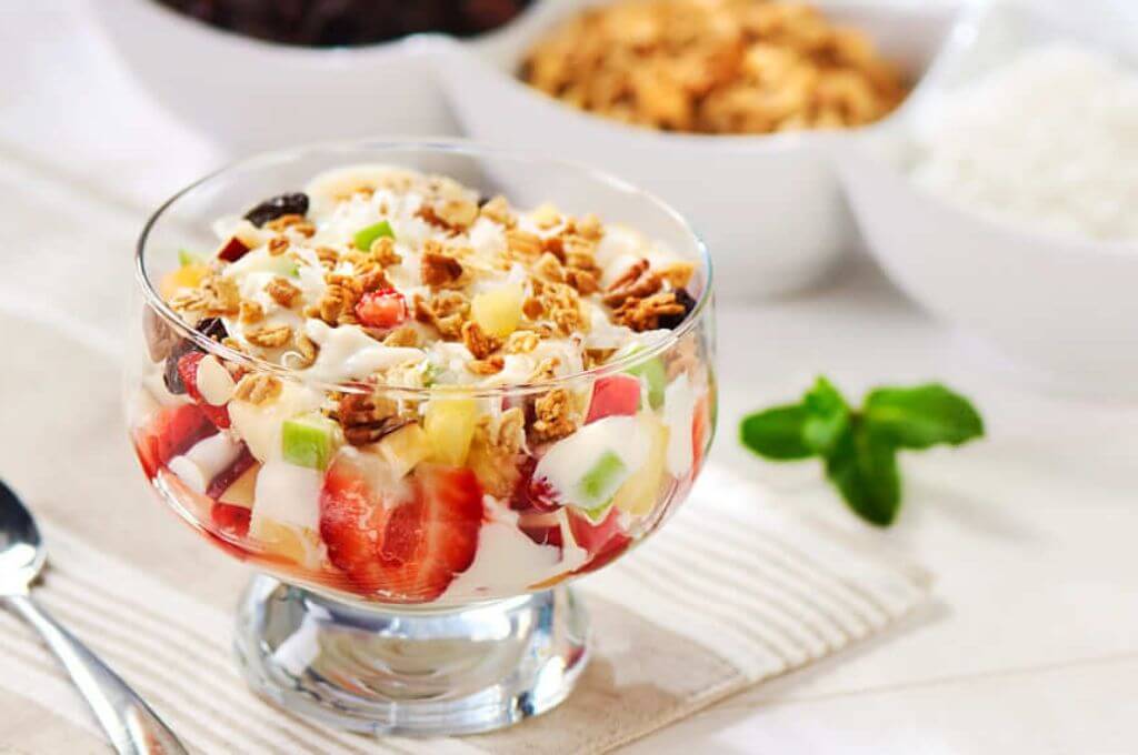 Tazón de yogur, granola y frutas en almíbar
