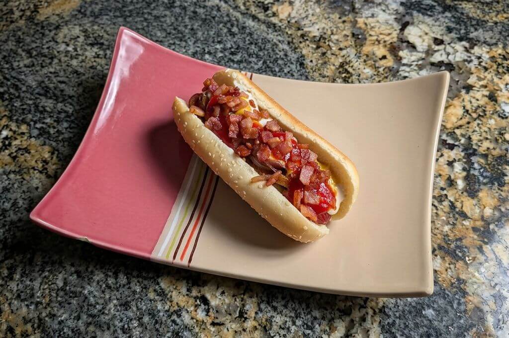 Hot dog con tocino y cebolla caramelizada
